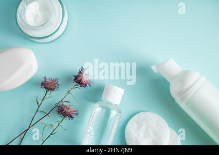 Produits cosmétiques et fleurs sèches sur fond bleu.Crème, lotion, savon et tampons de coton.Cosmétiques naturels à base de plantes.Soins de la peau, concept de bien-être.COP Banque D'Images