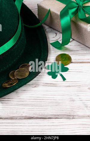 Chapeau Leprechaun, pièces d'or, trèfle shamrock et cadeau avec ruban vert sur fond blanc. Symboles bonne chance pour la Saint-Patrick. Vacances en Irlande. Banque D'Images