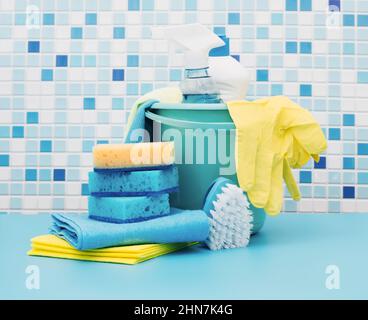 Nettoyants et détergents en seau, accessoires pour le nettoyage de diverses surfaces et pièces fond bleu Banque D'Images