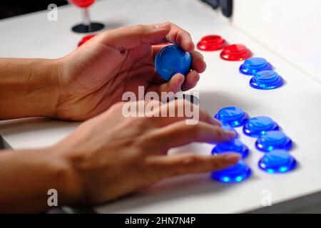 Détail des mains avec joystick d'arcade jouant vieux jeu vidéo d'arcade Banque D'Images