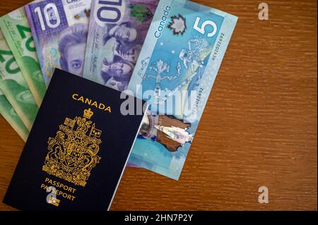 Vue du passeport canadien avec de l'argent canadien sur fond marron. Banque D'Images