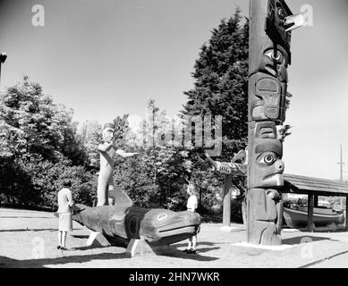 Photographie d'époque en noir et blanc de deux femmes qui regardent des totems de la côte nord-ouest et des sculptures dans le parc Thunderbird CA. 1940 à Victoria, Colombie-Britannique, Canada Banque D'Images