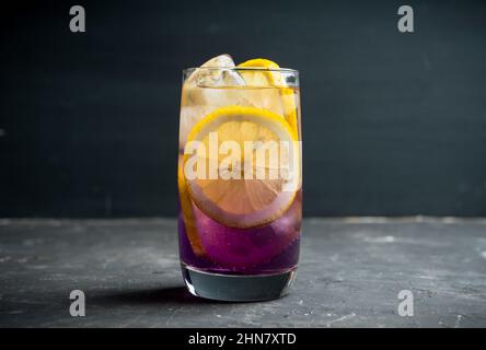 Cocktail coloré à base de gin avec liqueur de citron et de lavande sur fond rustique. Mise au point sélective. Faible profondeur de champ. Banque D'Images