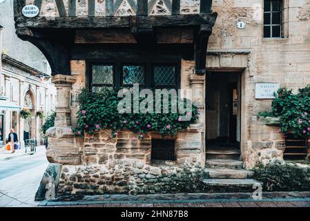Gros plan de fleurs en pot à l'extérieur de la fenêtre d'une ancienne maison en pierre Banque D'Images