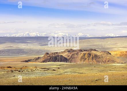 Vallée de Cui dans les montagnes de l'Altaï.Des falaises rocheuses, une plaine vallonnés au loin contre la crête enneigée du Nord-Cui sous un ciel bleu.Sibérie, Russie Banque D'Images