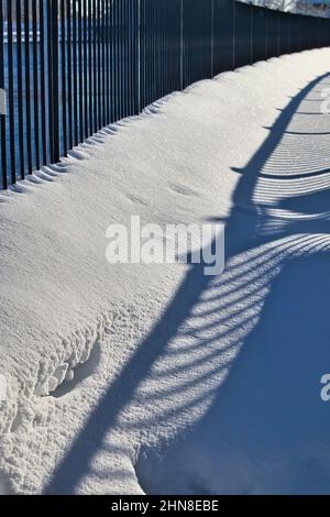 Ombres du rail sur la neige par temps ensoleillé Banque D'Images