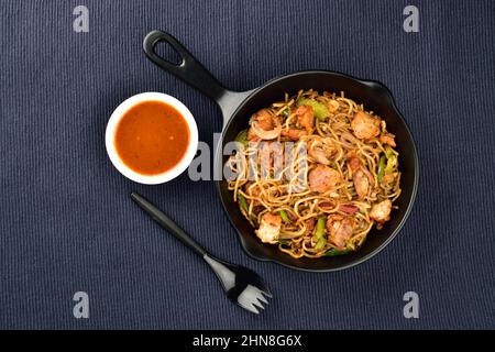 nouilles de poulet servies avec de la sauce sur un chiffon de cuisine bleu Banque D'Images