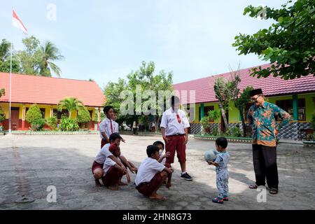 Lampung, Indonésie, décembre 17 2021- les élèves de l'école primaire jouent dans la cour d'école en portant des vêtements rouges et blancs dans un public Banque D'Images