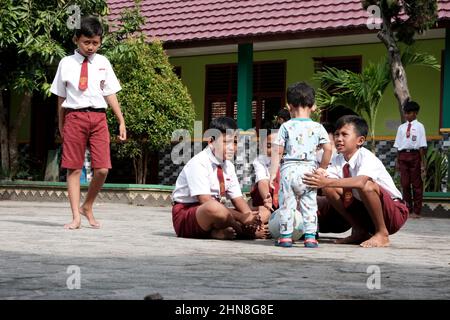 Lampung, Indonésie, décembre 17 2021- les élèves de l'école primaire jouent dans la cour d'école en portant des vêtements rouges et blancs dans un public Banque D'Images