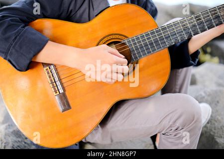 Lampung, Indonésie, février 12 2022- attention aux jeunes indonésiens jouant de la guitare sur la plage du village de Tridarmayoga, Lampung Indonésie Banque D'Images