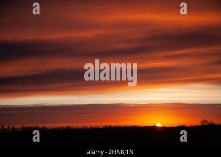 Le soleil se lève sur les Fens près de la ville marchande du Lincolnshire de Bourne, au Royaume-Uni. 15th févr. 2022. Royaume-Uni. Credit: Jonathan Clarke/Alamy Live News Banque D'Images