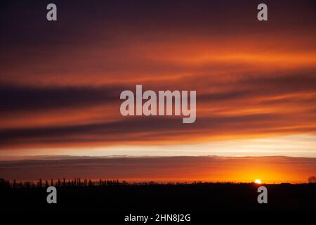 Le soleil se lève sur les Fens près de la ville marchande du Lincolnshire de Bourne, au Royaume-Uni. 15th févr. 2022. Royaume-Uni. Credit: Jonathan Clarke/Alamy Live News Banque D'Images