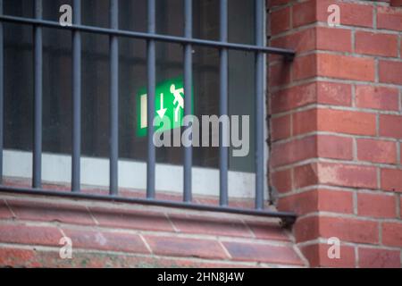 Pasewalk, Allemagne. 10th févr. 2022. Un panneau lumineux « sortie de secours » est suspendu au-dessus d'une porte du tribunal de district de Pasewalk. Le tribunal de district de Pasewalk (Vorpommern-Greifswald) traitera pour la première fois jeudi avec deux présumés passeurs qui ont amené des migrants de Biélorussie en Allemagne. La femme de 38 ans et l'homme de 39 ans sont accusés d'avoir violé la loi sur les résidences en faisant passer illégalement des étrangers. Les deux suspects polonais ont été arrêtés près de Löcknitz le 18 août 2021. Credit: Stefan Sauer/dpa/Alay Live News Banque D'Images