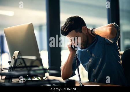 Burnout - mauvais pour les affaires, mauvais pour votre santé. Photo d'un jeune homme d'affaires stressé pendant une nuit de travail tardive. Banque D'Images