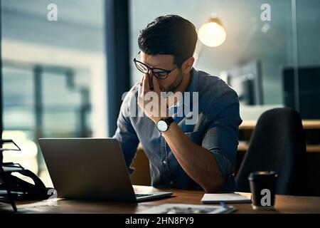 Burnout tue sa carrière. Photo d'un jeune homme d'affaires stressé pendant une nuit de travail tardive. Banque D'Images