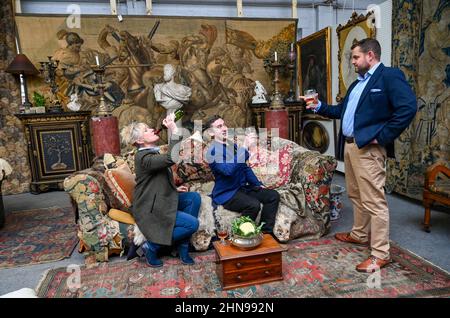 Billingshurst , Sussex, Royaume-Uni 15th février 2022 - de gauche Sara Cooper , Adam Garner et Wwill Pasfield de Bellmans Fine Art Auctioneers, Wisborough Green près de Billingshurst avec le célèbre canapé d'Oncle Monty qui est parmi les meubles vont à la vente aux enchères la semaine prochaine . Les articles de la maison du professeur Bernard Nevill, dont la maison de Chelsea était l'emplacement de l'appartement de l'oncle Monty dans le film 'Withnail & I ' qui célèbre son anniversaire de 35th cette année, seront mis en vente aux enchères la semaine prochaine le 23rd février : Credit Simon Dack / Alamy Live News Banque D'Images