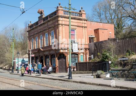 Derbyshire, Royaume-Uni – 5 avril 2018 : une petite foule attend le prochain tramway à l'arrêt Red Lion Pub & Cafe du musée national des tramways de Crich Tramway Village Banque D'Images