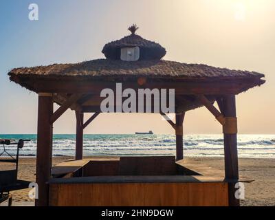 Silhouette de toit en bois avec barbecue en face de la mer Banque D'Images