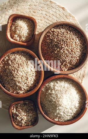 Ensemble de différents types de riz et de céréales dans des bols en bois Banque D'Images