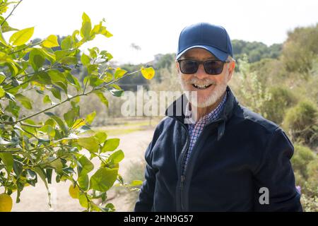 Portrait d'un homme souriant senior portant une casquette à l'extérieur. Banque D'Images