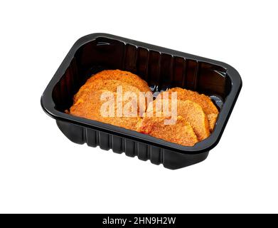 mini-schnitzel de porc cru dans un plateau en plastique isolé sur blanc Banque D'Images