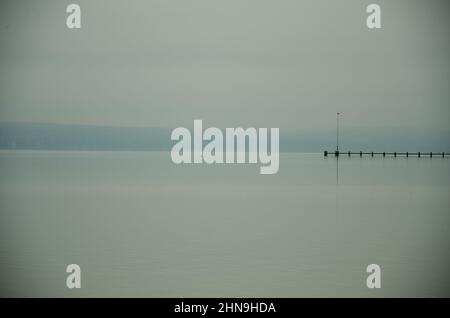 Une longue passerelle longieuse rejoint la brume Ammersee en Bavière. Montagnes à l'horizon Banque D'Images