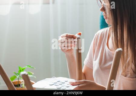 Une femme fixe un tampon de feutre sur la jambe de la chaise, en se souciant du sol Banque D'Images