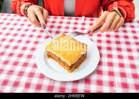 Une assiette de cuisine grecque authentique Moussaka sur une élégante nappe dans un restaurant avec une fourchette et un couteau. Spécialités traditionnelles dans les Balkans. Banque D'Images