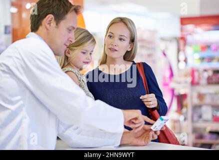 Votre pharmacien dispense également des conseils utiles. Un pharmacien donnant des médicaments à une mère et à une fille.