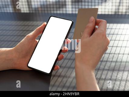 Paiement en ligne dans le concept APP. Mains tenant la carte de crédit et le téléphone. Maquette de smartphone. Femme magasiner en ligne. Photo de haute qualité Banque D'Images
