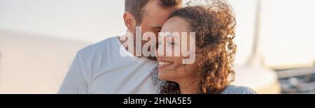 Portrait d'un couple charmant de touristes, homme et femme regardant heureux tout en se tenant à l'extérieur prêt pour embarquer dans l'avion au coucher du soleil Banque D'Images
