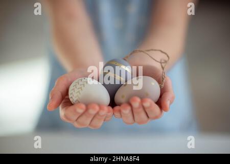 Photo en gros plan des mains des enfants qui retiennent les œufs de pâques le jour ensoleillé du printemps Banque D'Images