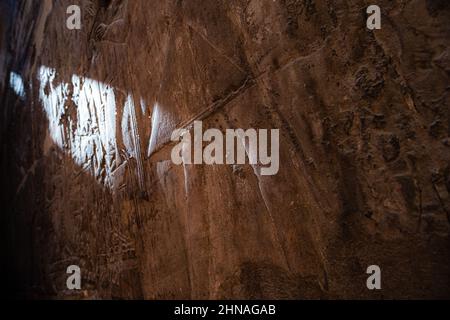 Vue du mur sur un temple aléatoire en egypte, couvert de hiéroglyphes, lumière rayonnant une partie du mur Banque D'Images