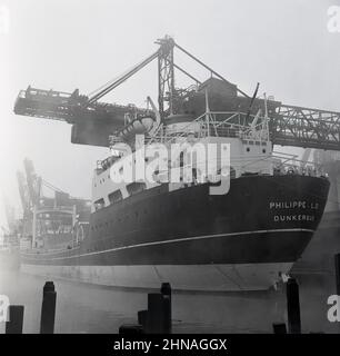 1950s, historique, le navire à conteneurs Louis Dreyfus, Philippe. D.E. (II) de Dunkerque chargé de lourdes charges en acier au quai industriel de Port Talbot, pays de Galles, Royaume-Uni. Un contrat avec The Steel of Company of Wales a vu ce navire construit, le deuxième avec le nom de Phamppe LD. Un porte-minerai de conception tout-arrière et un tirant peu profond le navire a été spécialement développé pour les ports industriels britanniques. Les quais flottants ont fermé à l'expédition en 1959. Banque D'Images