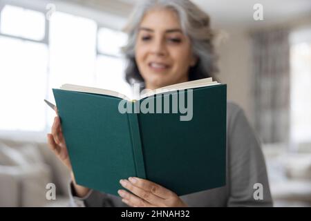 Femme mature écrivant dans un journal ou un agenda à la maison Banque D'Images