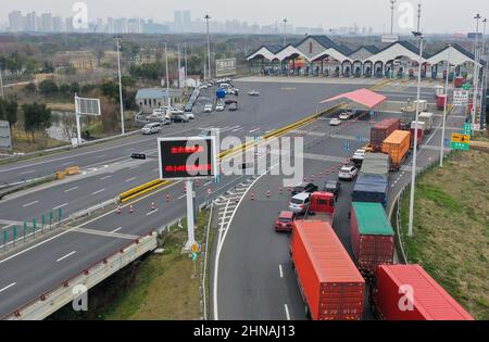 Suzhou. 15th févr. 2022. La photo aérienne prise le 15 février 2022 montre les véhicules qui attendent d'être vérifiés à la station de péage de Suzhou New District de l'autoroute Beijing-Shanghai à Suzhou, dans la province de Jiangsu, dans l'est de la Chine. Depuis février 15, Suzhou a fermé 15 entrées d'autoroute et installé 31 points d'inspection de sortie d'autoroute dans toute la ville. Les conducteurs et les passagers doivent porter une preuve des résultats négatifs des tests d'acide nucléique effectués au cours des 48 heures précédentes, ainsi que des codes de santé verts. Credit: JI Chunpeng/Xinhua/Alamy Live News Banque D'Images