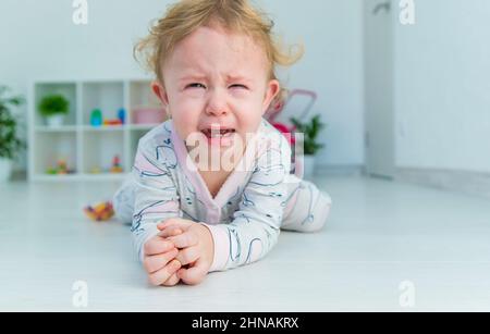 Bébé pleure beaucoup à la maison. Mise au point sélective. Enfant. Banque D'Images