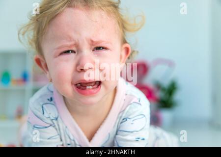 Bébé pleure beaucoup à la maison. Mise au point sélective. Enfant. Banque D'Images