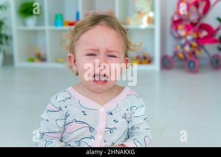 Bébé pleure beaucoup à la maison. Mise au point sélective. Enfant. Banque D'Images