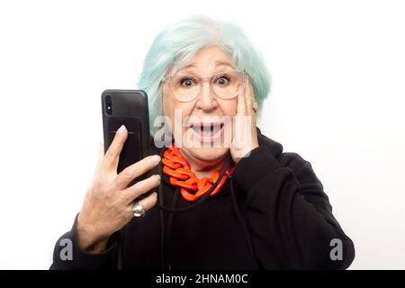 femme à la mode avec bouche ouverte et téléphone cellulaire à la main sur fond blanc Banque D'Images