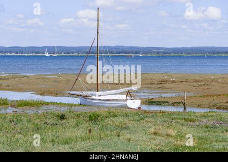 Scène pittoresque de bateau amarré à marée basse dans le port de Chichester avec Hayling Island à distance près de Chichester, West Sussex, Angleterre, Royaume-Uni Banque D'Images