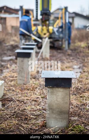 Forage de pieux de béton avec machine à piquage, fondation pour la maison de cadre en bois, travaux de sol Banque D'Images