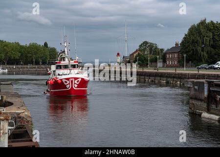 Un bateau de pêche entre dans le port de Normandie, en France Banque D'Images