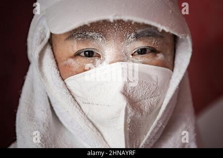 Wuhan, Chine. 15th févr. 2022. Un employé voit son visage couvert de poussière lors de la fabrication de Tangyuan (également connu sous le nom de boulettes de riz gluant ou simplement appelé boulettes de Yuanxiao chinois) lors d'un atelier pour le Festival Lantern. Le festival Lantern, également appelé festival Shangyuan est un festival traditionnel chinois célébré le quinzième jour du premier mois dans le calendrier lunisolaire chinois pendant la pleine lune dans les pays d'Asie du Sud-est. Crédit : SOPA Images Limited/Alamy Live News Banque D'Images