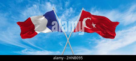 Drapeaux nationaux croisés de France et drapeau turc agitant dans le vent à ciel nuageux. Symbolisant la relation, le dialogue, les voyages entre deux pays. Banque D'Images