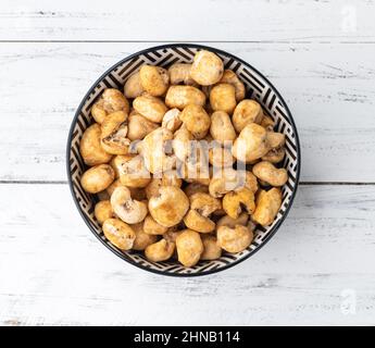 Canjica, maïs soufflé à la fois hominy ou blanc, pop-corn sucré dans un bol sur une table en bois. Banque D'Images