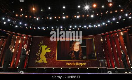 Berlin, Allemagne. 15th févr. 2022. Présentation de l'ours d'or honoraire de Berlinale à l'actrice française Huppert : Isabelle Huppert Merci pour le prix. Le directeur Laurent Larivière est sur scène avec le prix qu'il a accepté au nom. Sur la gauche se trouve le laudator Lars Eidinger. Le directeur de Berlinale, Carlo Chatrian, se trouve sur la droite. Huppert n'était pas présent en personne à la cérémonie de remise des prix mais n'était connecté que par vidéo. Elle avait annulé sa visite initialement prévue au festival du film à court terme après avoir été testée positive pour le virus Corona. Credit: Monika Skolimowska/dpa/Alay Live News Banque D'Images