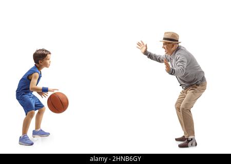 Photo pleine longueur d'un grand-père et d'un petit-fils jouant au basket-ball, isolée sur fond blanc Banque D'Images