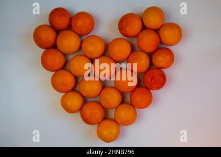 coeur fait d'oranges entières sur fond blanc Banque D'Images