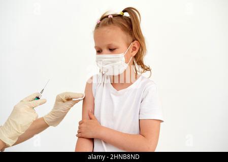 Une petite fille a peur des vaccinations, des injections et des vaccinations. L'enfant est vacciné contre le coronavirus. Banque D'Images